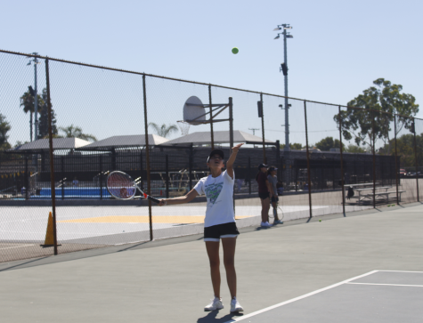 Sophomore Carolyn Tran starts her tennis serve toss during practice at Aug. 14. Photo taken by Accolade photographer Brianna Zafra.