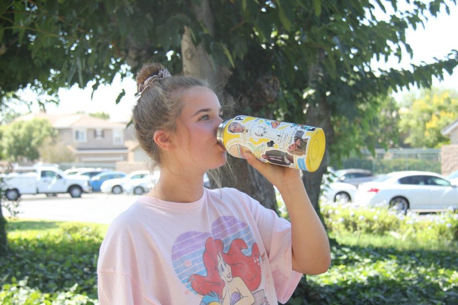 Junior Jenna Beining drinks water from her yellow colored Hydro Flask covered in stickers on Sept. 15. Photo taken by Accolade photo editor Megan Shin. 