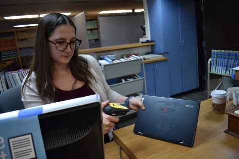 Librarian technician Laura Prompongsatorn scans one of the new Lenovo model Chromebooks on Aug. 13 in the school library. The Chromebooks were distributed to freshmen at the beginning of the school year. (Photo taken by Accolade photographer Paul Yasutake)