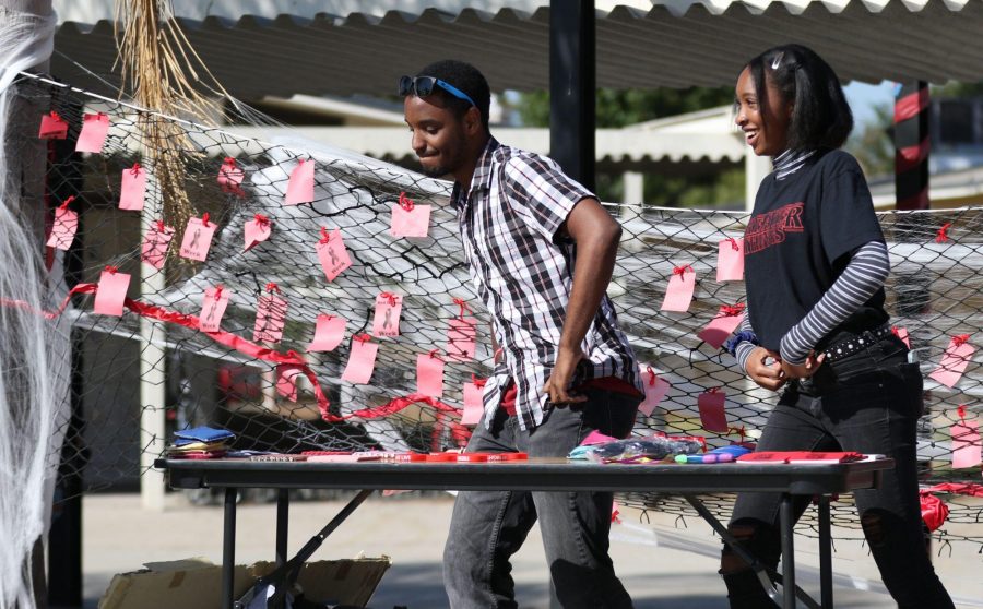 Seniors Branden Elliott (left) and Kourtney Barbour dance to the music in the quad Oct. 29 while helping man the Friday Night Live bean bag toss game as part of the weeks Red Ribbon Week festivities. Behind the two is the Net of Memories, which contains messages written on red pieces of paper from students whose loved one has been affected by drugs or other addictive substances. Photo taken by Accolade photographer Paul Yasutake