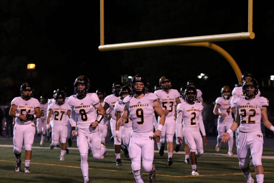 Linebacker junior Carson Irons (center) leads the Lancers on to the Trabuco Hills High School field in Mission Viejo during the Nov. 22 CIF Southern Section Division 8 semifinal game against the Mustangs. Irons made the game-saving interception off a tipped ball at the one-yard line with less than seven seconds left in the game. Photo taken by Accolade photographer Paul Yasutake