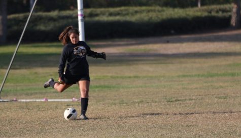 Junior goalkeeper Cil Avila kicks off the soccer ball during a goalkick in practice Nov. 7 at the field next to Hydroflow. Photo taken by Paul Yasutake