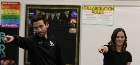 Science teacher Christopher Ghareebo (left) holds his hand out while dancing to