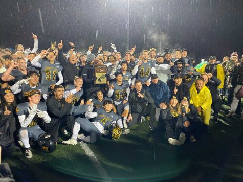 The Lancer football team celebrates its first CIF title in 27 years by posing with the championship plaque in the rain Nov. 30 at San Marcos High School stadium. Photo taken by Accolade photographer Paul Yasutake