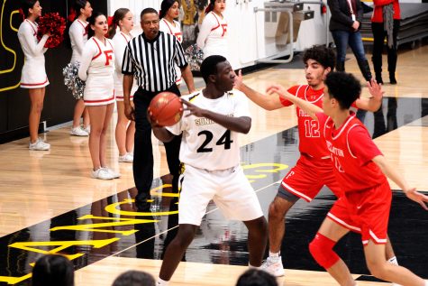 Sunny Hills boys basketball forward senior Emmanuel Seddoh (left) searches for a teammate to pass the ball to while being double-teamed during the second quarter of the Lancers' 72-65 victory at home over Fullerton Feb. 4. Photo taken by Accolade photographer Brianna Zafra