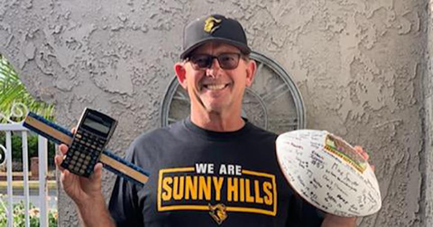 Larry Allen holds in one hand a calculator and ruler to represent the math classes he has been teaching at Sunny Hills, while his other hand holds a football signed by his 2018 Freshman City Championship players. Image posted with permission from Aurora Allen.
