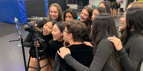 Members of Dance Production check out photos taken for the spring dance concert program during a Feb. 20 rehearsal in Room 130, the dance room. Though the April 9-11 event was canceled because of COVID-19-related school closure, dance instructor Leiana Volen has posted seven videos on the Dance Department's Instagram and YouTube channels of various video footage of her students rehearsing their routines to showcase their hard work in preparation for the performance. Image posted with permission from Leiana Volen.
