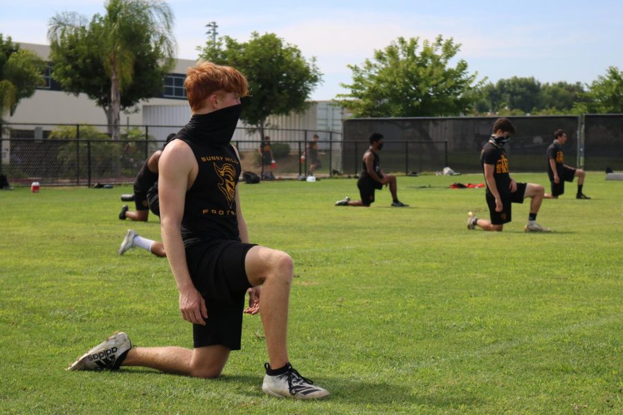 Defensive back rising junior Dane Soaper kneels while stretching following a June 23 practice on the Sunny Hills baseball field. The SH football team had been preparing to defend its 2019 CIF-SS Division 8 title when the Orange County Department of Education opened schools for sports summer workout sessions but now must wait until January 2021 to play under Friday night lights again.