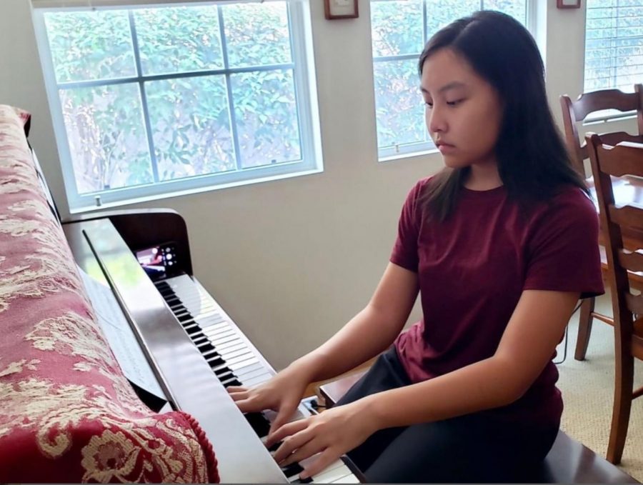 With her iPhone placed on the far right end of her piano set for video recording, sophomore Lauren Pak starts her practice session Aug. 19 from her Fullerton home, playing a composition titled, “Promise of the World,” from the Japanese anime, “Howl’s Moving Castle.”  Pak will eventually record the final version as a trio with two other student volunteers as part of the Harmony4Homes community service project that she started in the summer to send video music performances to the elderly in local and national nursing homes. 
