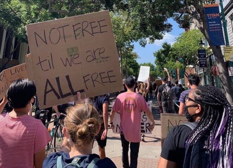 Senior Hanna Oltman uses her iPhone 11 to take an image of protestors in Downtown Fullerton on June 7 chanting for justice after the death of George Floyd.