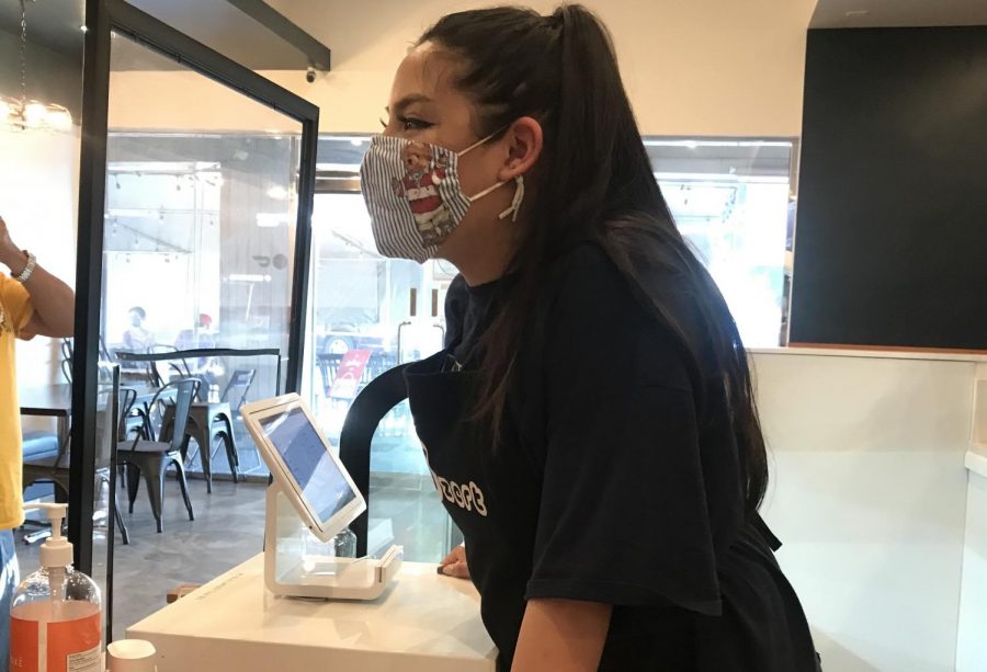 Senior Gianne Veluz wears a mask as she takes customers’ orders during her shift at a dessert cafe in Buena Park on Sept. 19.
