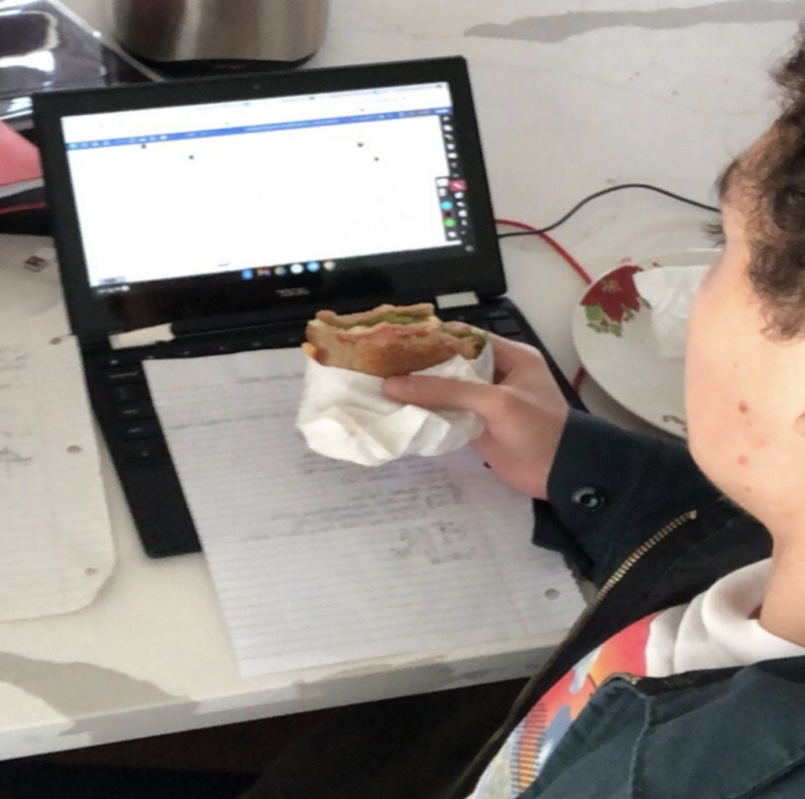Junior Guillermo Soto attends class while eating a burger. Like many other Sunny Hills students, Soto elected to stay at home when the hybrid schedule begins on Nov. 2.