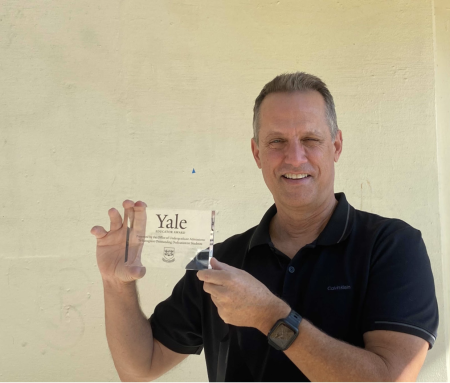 Art teacher and International Baccalaureate coordinator Brian Wall holds up the 2020 Yale Educator Award after receiving it in the mail last September. 