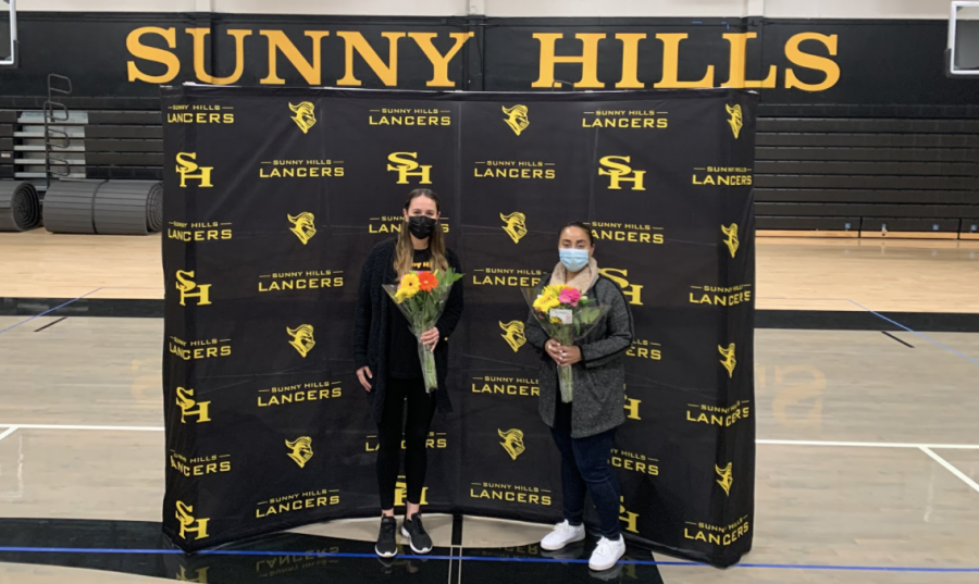 Dance teacher Leiana Volen (left) and guidance technician Evelyn Casillas stand inside the Sunny Hills gym holding flower bouquets at the surprise event planned for their acceptance of the certified teacher and classified employee of the year awards on Jan. 29.