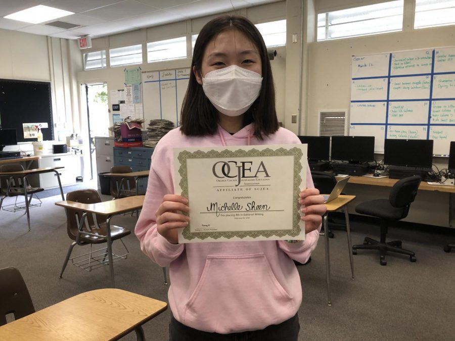 Accolade copy editor junior Michelle Sheen holds her fourth-place certificate in the editorial writing category of the Orange County Journalism Education Association writeoffs contest. Sheen picked up her award Monday, March 1, from The Accolade room, Room 138, after school.