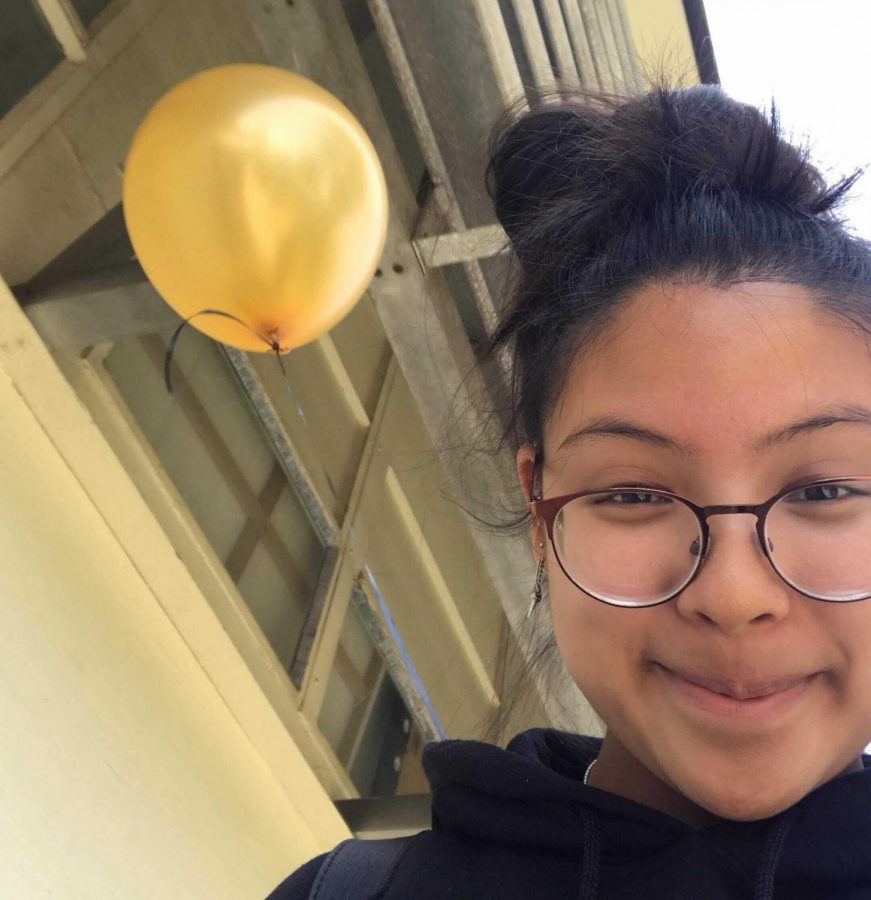 Then-sophomore Gianne Veluz takes a selfie with her Lancer gold helium balloon in the background after she got inducted into the National Honor Society during fourth period in May 2019. While the club is still seeing an interest in new applicants, it has been unable to carry out any of its induction traditions since the coronavirus pandemic broke out a year ago in March. 