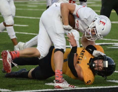 Linebacker senior Carson Irons (bottom) falls down while tackling Fullerton quarterback senior Cameron Williams during the first quarter of the Lancers' 31-7 win over Fullerton. Williams subbed in for starting quarterback senior Dylan Neal during several offensive series in the first quarter.