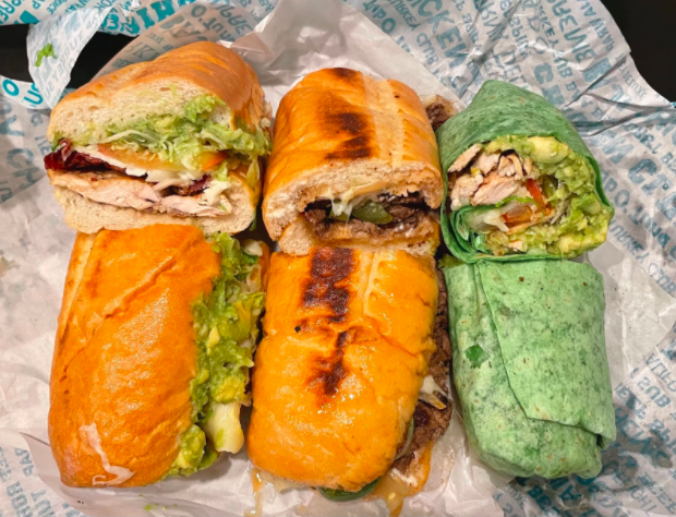 Board and Brew makes all of its sandwiches — including the $9.50 Chicken Club (left), $12.95 Baja Beef and $8.95 Baja Wrap — with fresh ingredients and its secret, gluten-free, nut allergy free, vegan-friendly sauce.