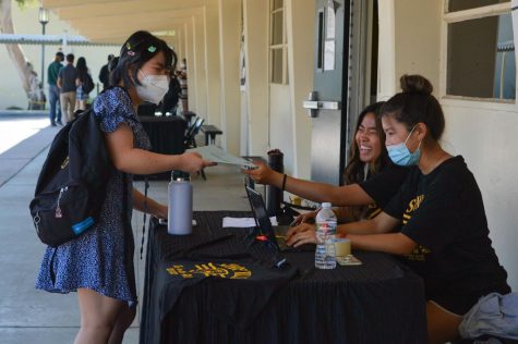 Senior Ashley Hoang (left) hands over her spirit wear form to senior Elaine Chu during Lancer Day on Aug. 10. The Aug. 10-released school health and safety guidelines now allow anyone on campus to be mask-free when outdoors.