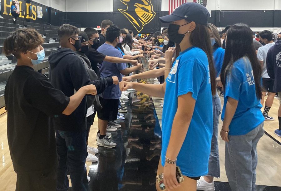 Link Crew leader senior Jessica Kim (right) gets ready for a fist bump to greet a freshman during the line rearranging activity in the gym. A total of 500 ninth-graders attended the Link Crew-sponsored freshman orientation that started in the gym and continued in various classrooms where upperclassmen had a chance to socialize with a smaller size of the incoming Sunny Hills students.