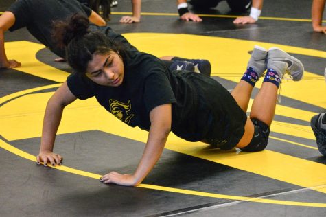  Junior Kylie Yang works on conditioning alongside fellow teammates during a Nov. 15 practice at the wrestling room (Room 153). 