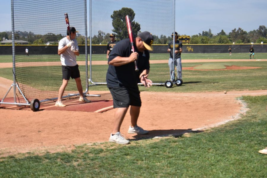 New head coach Ryan Bateman demonstrates a hitting stance during the Thursday, May 5, practice after school on the baseball field.