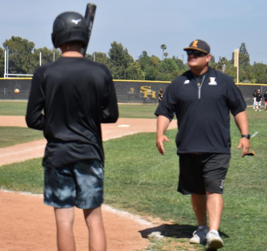 New baseball head coach Ryan Bateman walks toward some of his players during batting practice Thursday, May 5, after school on the Sunny Hills baseball field. Bateman has led the Lancers to their first Freeway League title since 1999.