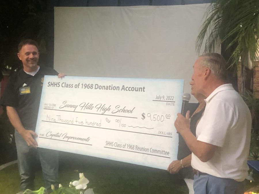 Principal Craig Weinreich, left, accepts the giant check for $9,500 from Class of 1968 reunion committee board members, Brad Rawlins and Pat Hartunian Simonian, on July 9 outside alumna Kathy Nelson Zibulsky ’s home in Fullerton. The 54th-year reunion was held there as well.