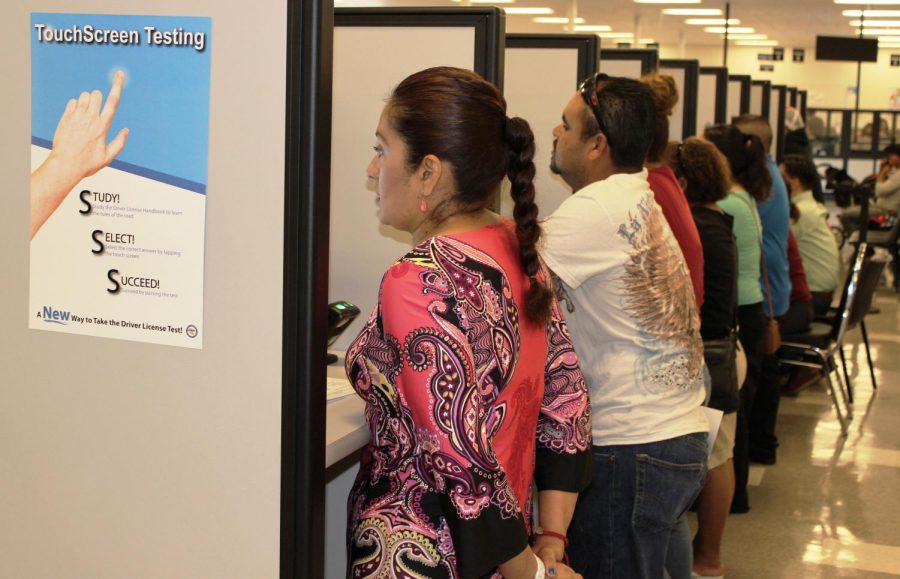 Customers gather at their local Department of Motor Vehicles field office to take their driver's knowledge test on a touch screen device June 2015.