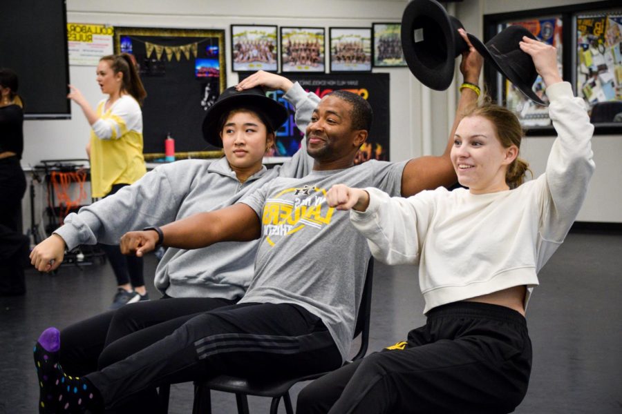 Junior Ashley Hong (left), athletic director Paul Jones and senior Jaden Michel incorporate a hat and chair for their prop in their Dancing With the Staff rehearsal Thursday.
