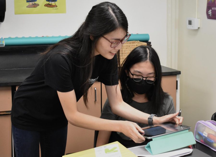 Using an iPad, new math teacher Christina Vu (left) assists freshman Terah Nohl in her fourth period Algebra 2 Honors class in Room 105 at the beginning of the fall semester.