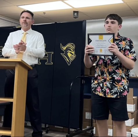 Principal Craig Weinreich (left) applauds after presenting freshman Boyd Houser with a certificate in the Lyceum at a recent Parent Teacher Student Association meeting. Houser is among the first group of students to receive the new award in which teachers nominate  students for their effort and participation in the classroom.