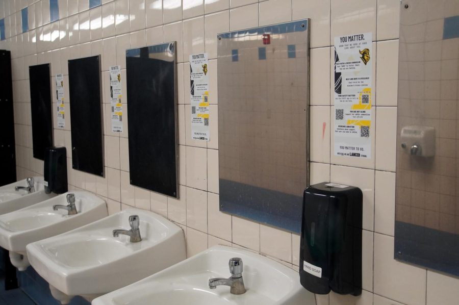The girls restroom in the quad displays a mental wellness sticker between the mirrors, listing several helpline services and three QR codes on Thursday, Feb. 2. The Fullerton Joint Union High School District distributed personalized posters for each school, consisting of the school colors and mascot.