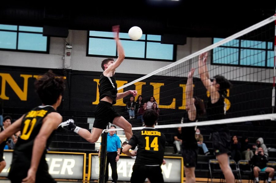 Middle blocker senior Ryan Axe gets ready to spike the ball against the Cerritos Dons in a preseason match Thursday, March 9, in the Sunny Hills gym. The Lancers defeated the Dons in four sets, 3-1.