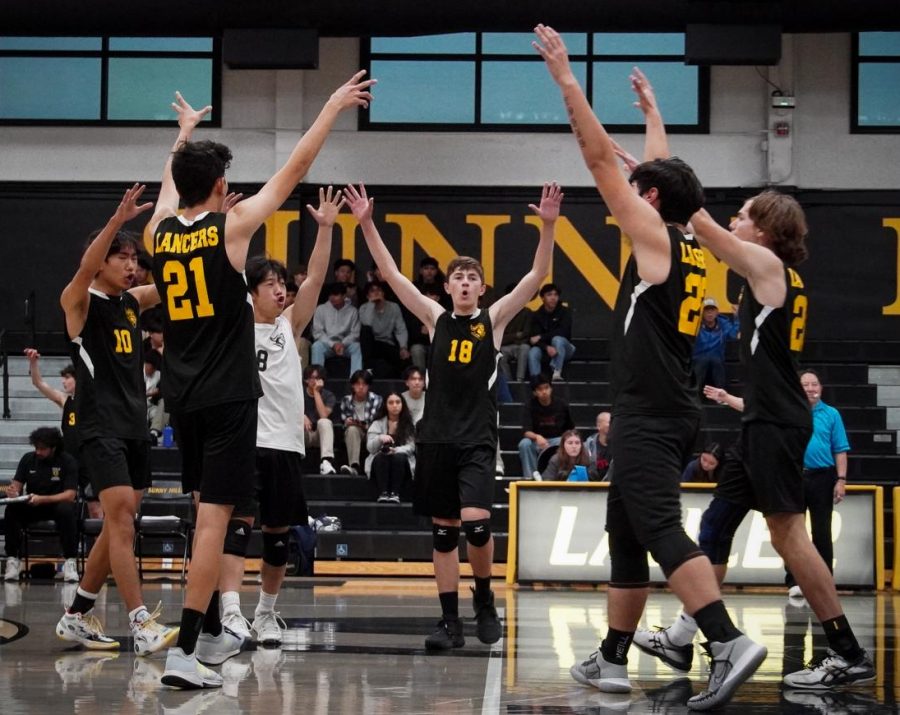 The boys volleyball team celebrates a point against Cerritos on Thursday, March 9, in the Sunny Hills gym. After losing the first set, the Lancers bounced back and swept the next three to win, 19-25, 25-20, 25-18 and 26-24.