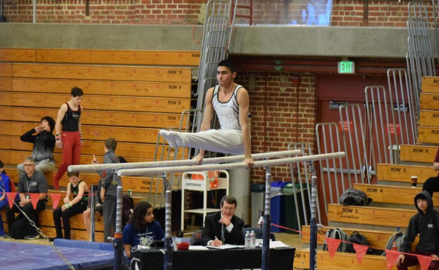 Gymnast senior Andrew Gonzalez performs an L-sit at a Stanford University competition Jan. 28. This was the second level-nine meet for him and freshman Cailean Travis, his teammate.