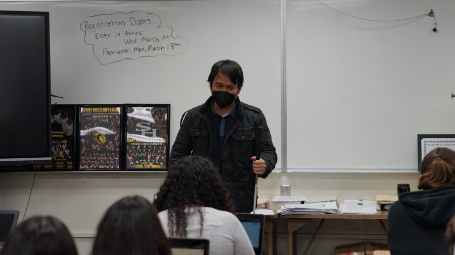 With a white cane in his hand, student teacher Isaac Rico gives his English 3 fifth period students instructions for taking a test in Room 57 on Monday, Feb. 27. 
