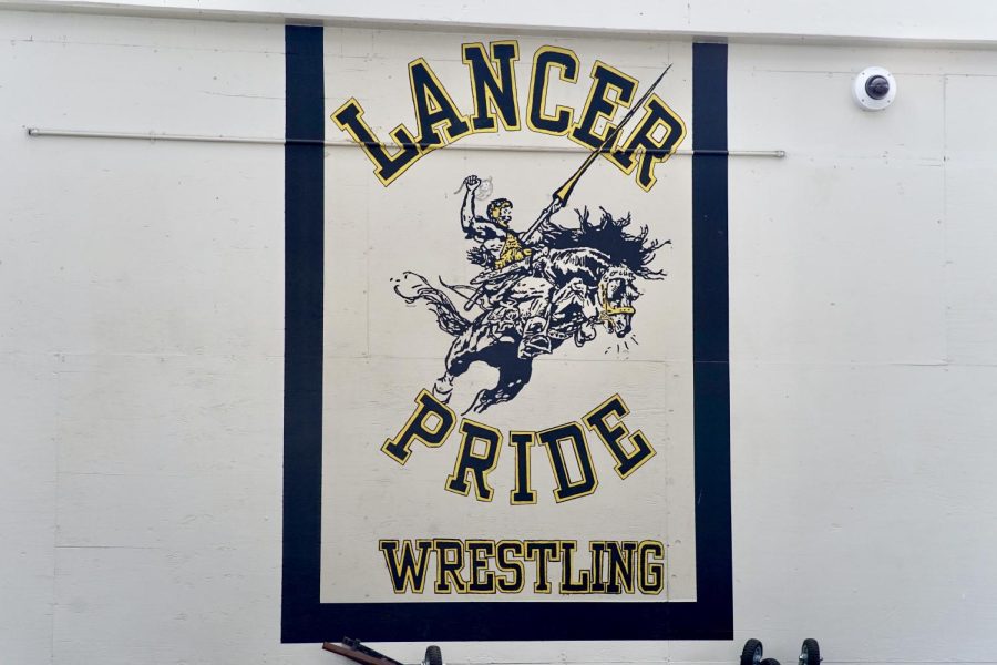 The mural in the cafeteria displays “LANCER PRIDE WRESTLING” written in black and gold with a horse rider painted between the letters.