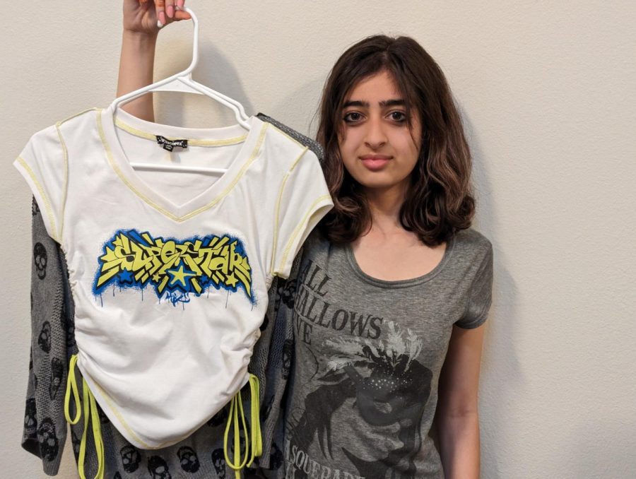 THE TRUE COST OF FAST FASHION: Freshman Natasha Niazi holds up a T-shirt and a long-sleeve top that she thrifted in Fullerton for $10 and $8, respectively. After starting her thrifting journey in 2020, Niazi has saved money while simultaneously reducing waste.