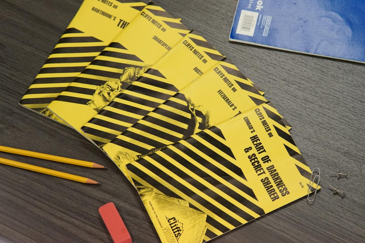 Several paperback CliffsNotes lay in the center of a school desk in Room 138, immediately recognizable by their black-and-yellow striped design.
