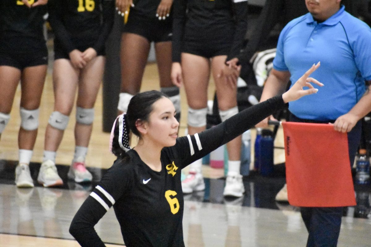 Outside hitter senior Kayla Taylor holds up two fingers to signify the number of available hitters for the opposing team during the quarterfinal match against Windward School on Wednesday, Oct. 25.