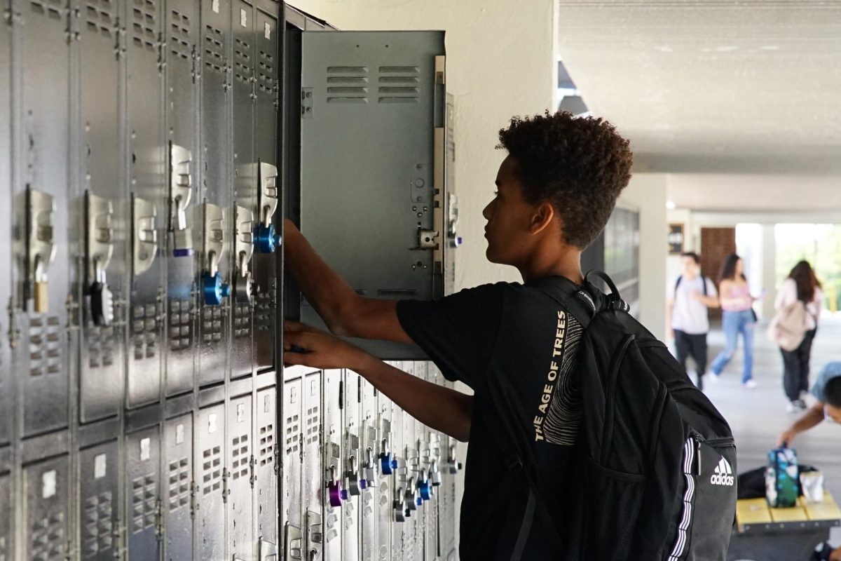 Freshman Eli Anizor puts his belongings into his designated locker between the 20s and 40s buildings during lunch Tuesday, Sept. 26. Over the summer school officials contracted with Color New Co. and spent $390,000 to paint the lockers black and changed the colors on all buildings to a neutral gray-white.