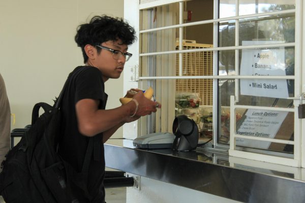 Freshman Matthew Gallardo rushes to pick up his lunch meal at the RoundHouse on Monday, Oct. 16, during lunch. In the 2023-2024 school year, more students have picked up meals because of improvements made to school lunches.