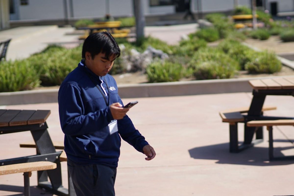 Junior Carlos Pineda walks to the boys restroom in the 40s building last month after activating his restroom pass through the 5-Star app in his fourth period class along with his class’s designated physical hall pass on a lanyard.