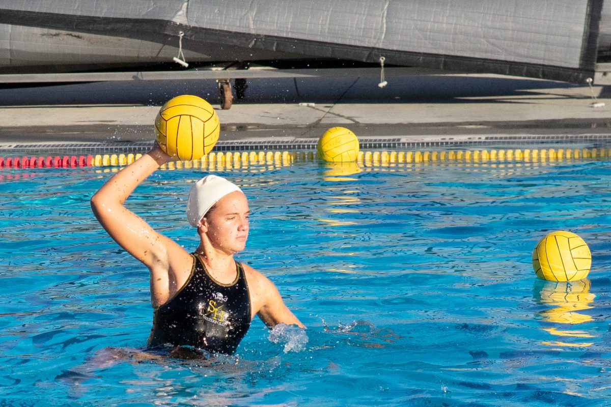 Utility player sophomore Lauren Jacobsen gets ready to throw the ball during the girls water polo practice on Tuesday, Dec. 12 at the Sunny Hills pool. 