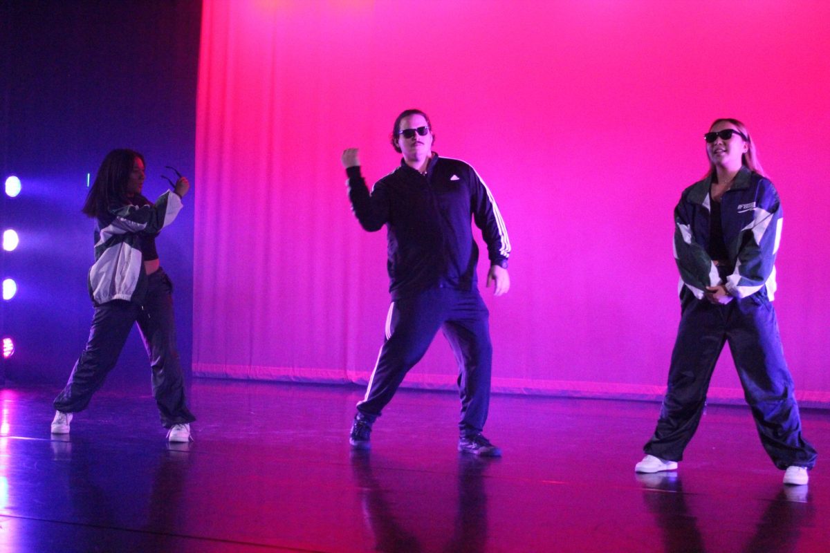 Social science teacher Christopher Collodel (center) swings his right arm to “You Dropped a Bomb on Me,” an ‘80s song by The Gap Band, while juniors Maddy Boyd (left) and Chloe Park strike a pose during the dress rehearsal of the annual Dancing With the Staff performance on Wednesday, Dec. 6 in the Performing Arts Center [PAC]. The live performance from 7 p.m.-9 p.m. on Thursday, Dec. 7, and Friday, Dec. 8, featured a record-breaking number of faculty – 19 – including School Resource Officer Gene Valencia and athletic director Paul Jones.
