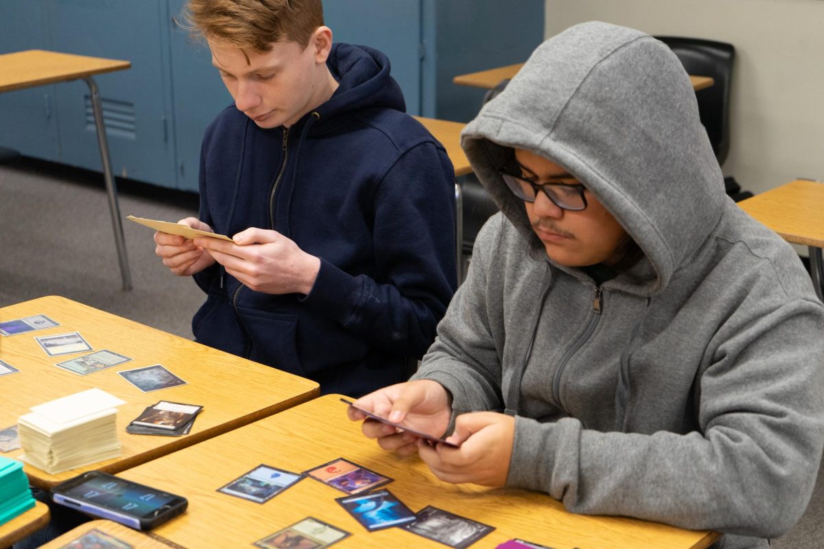 Junior Brendan Barnett (left) and Sophomore Enrique Morales play Magic the Gathering during the club’s lunch meeting in Room 75 on Thursday, Jan. 11. The game involves using a 60-card deck with monsters and spells to reduce the opponent’s life points.
