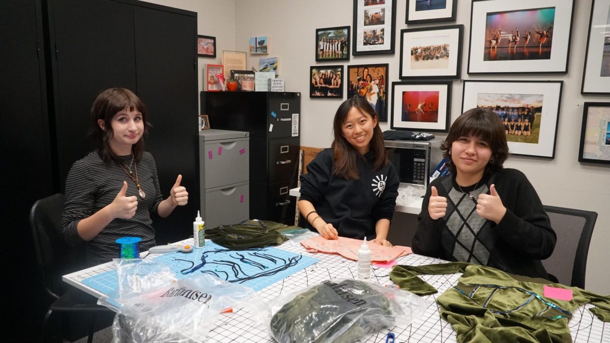 Freshman Mollie Mclain (left), senior Alison Chan and junior Katie Handley assist in bedazzling costumes for Dancing with the Staff after school in Room 130 on Monday, Dec. 4.