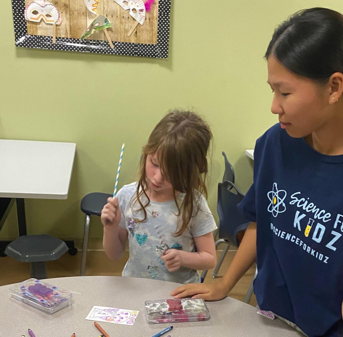 Science for Kidz club member junior Amy Roh (right) helps a child construct a paper hoop glider at the Boys & Girls Club of Fullerton on Tuesday, Nov. 7. Roh serves as co-president of the Sunny Hills chapter with two other students. 