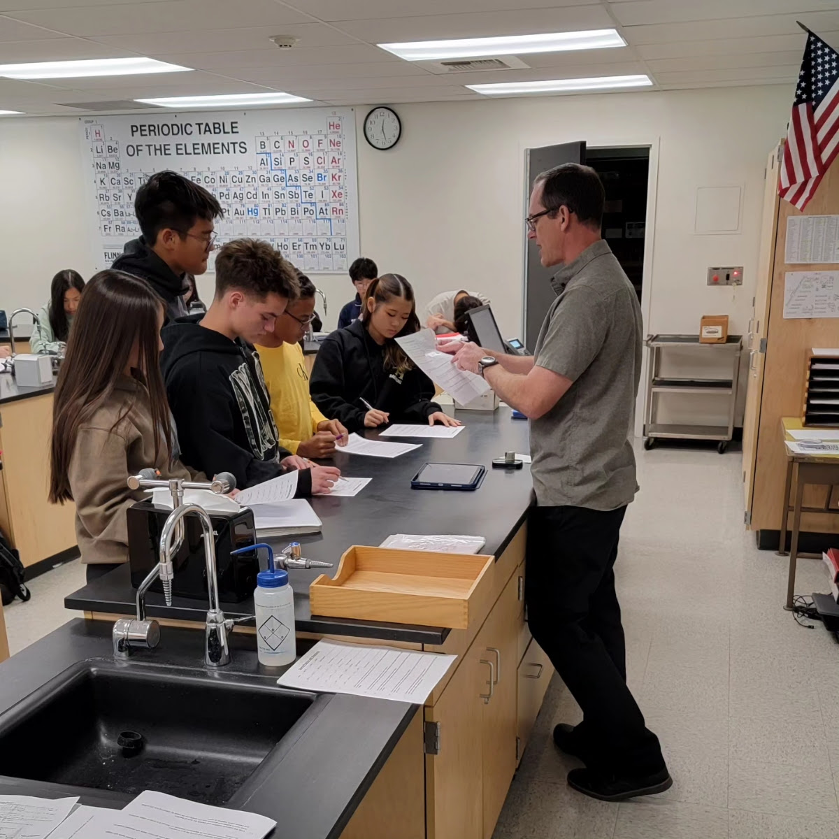 Science teacher Andrew Colomac (right) helps his fourth period Honors Chemistry students check their answers from the printed worksheets they completed, which was the adjustment Colomac made as students were unable to access them on Google Classroom because of the second day of the network outage on Wednesday, Nov. 15. (Image used with permission from Craig Weinreich)